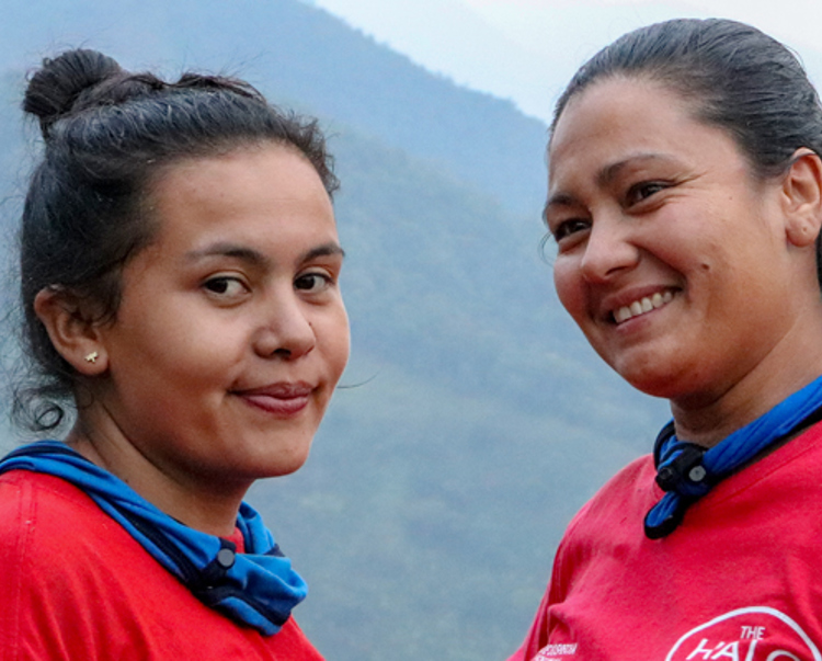 Two women in HALO T-shirts smile outside