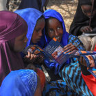 Children from a risk education session in Mandheera village hold a HALO booklet
