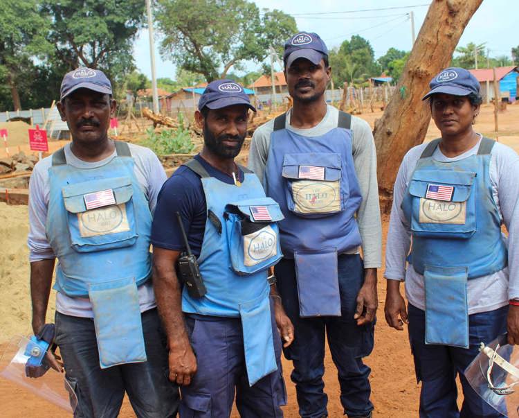 The mechanical demining team pose together outside