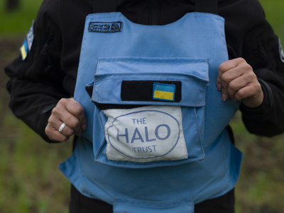 A light blue HALO Trust vest with the Ukrainian flag above it.