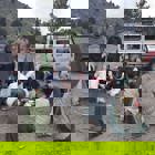 Residents of Khost gather round HALO medical professional as he treats a man on the ground