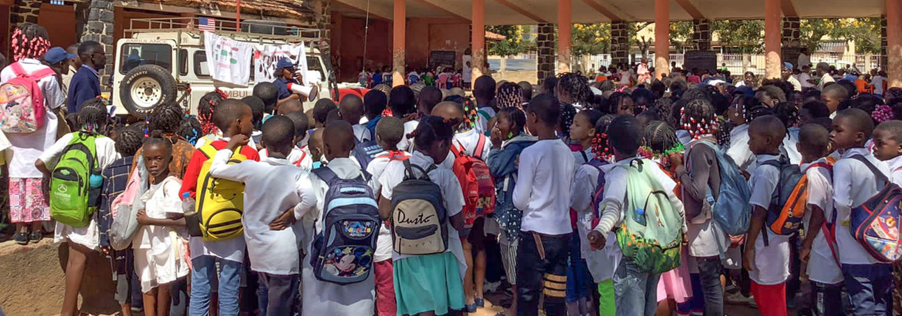 A group of school children stand outside for a class on explosive ordnance risk education