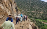 Trucks and personnel travel up a mountainside in Afghanistan.