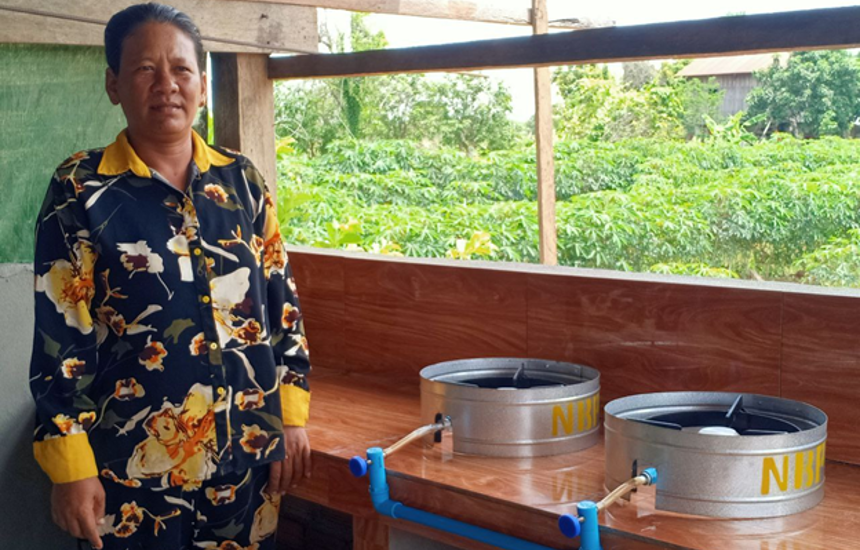 A women stands next to two metal components indoors