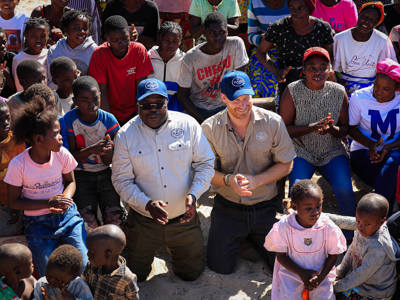 Duke of Sussex with HALO team and local community children.