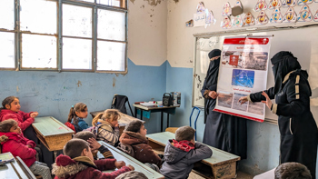 Children sit in a classroom for a risk education session led by HALO staff members
