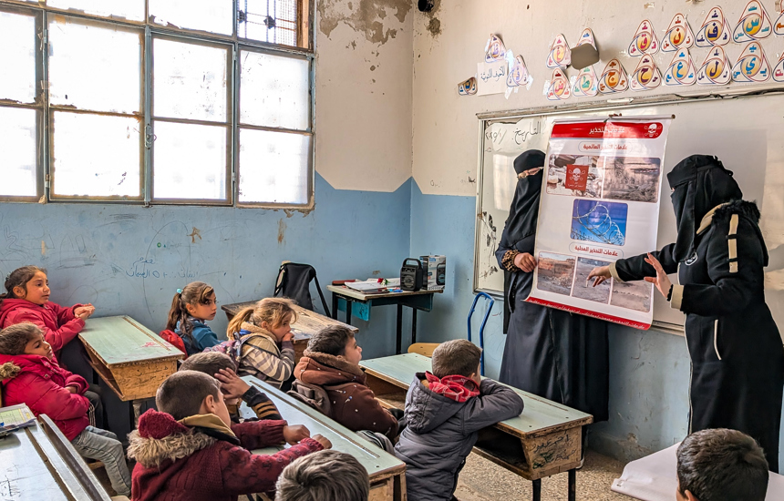 Children sit in a classroom for a risk education session led by HALO staff members