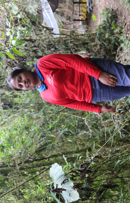 A deminer poses in the middle of a forest