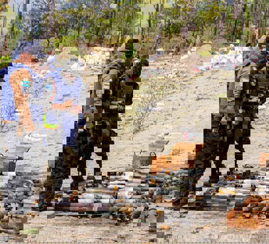 People in HALO vests gather round a stockpile of weapons in Honduras