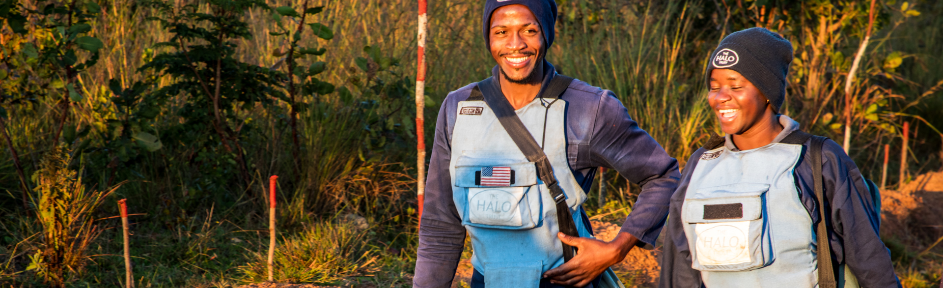 HALO Angola landmine clearance staff, walking through a minefield smiling