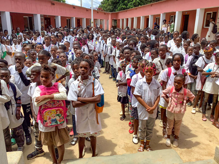 kids stand outside Kambulukuto School, Cuito, Angola
