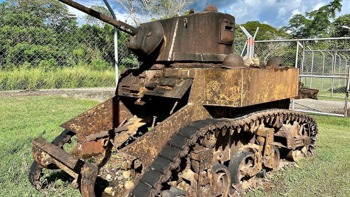 A rusted WW2 tank in a fenced off area in the Solomon Islands