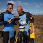 HALO staff work with a Trimble device on a minefield