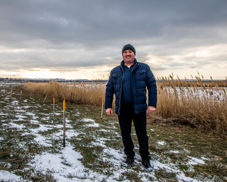 Head of Vasylivka village, Ivan Gentosh, stands next to the Inhulets river where hundreds of explosives were cleared.